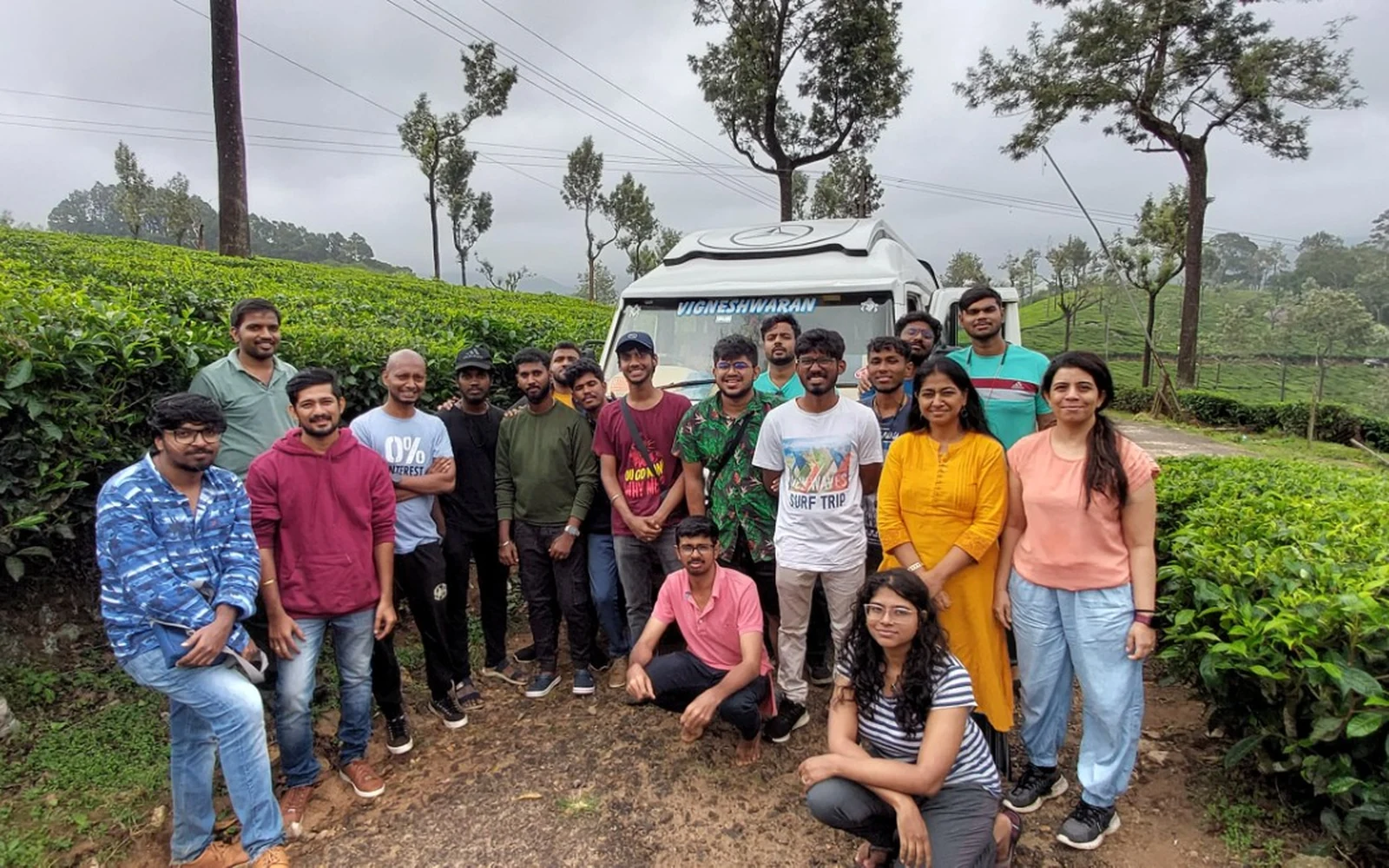 Vigneshwaran Tours and Travels customers with a Tempo Traveller in a tea estate